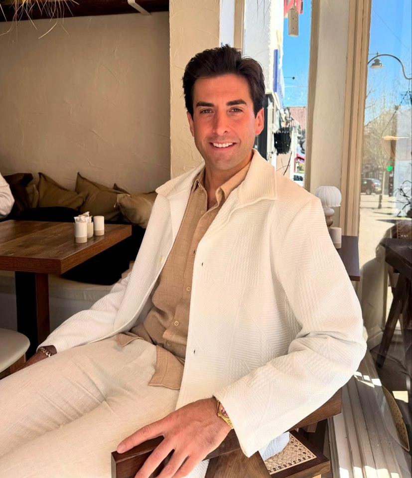 Man in white jacket sitting at a cafe.
