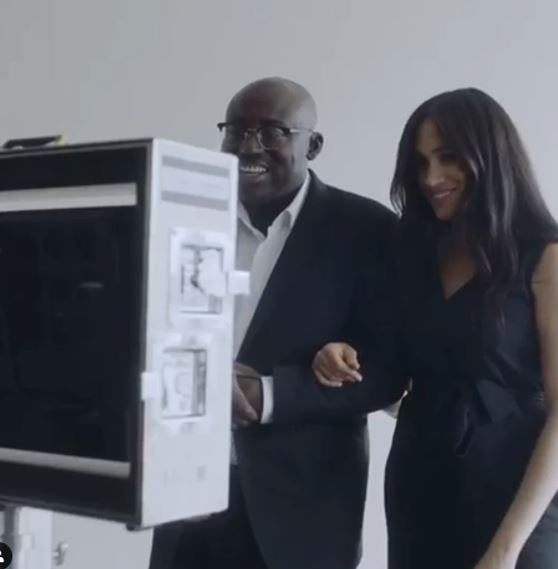 Meghan Markle and a man looking at a photo booth.