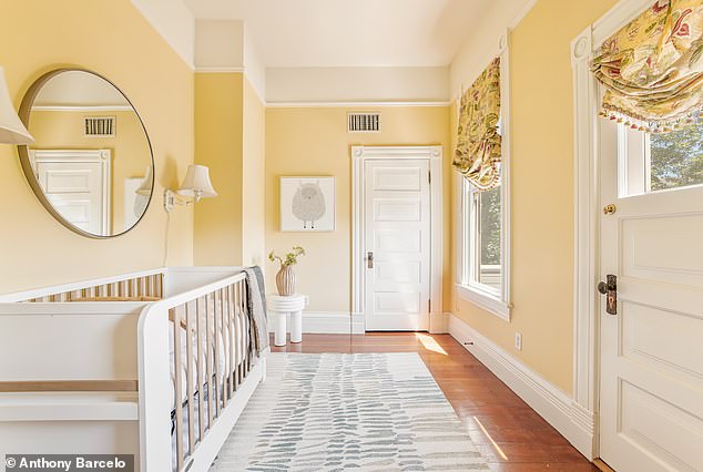 Light-filled yellow nursery with decorative window shades