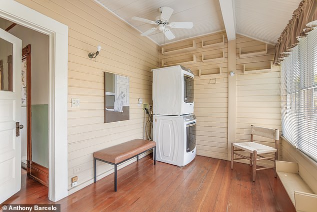 The quaint laundry room that includes a washer and dryer and a seating area to fold clothes