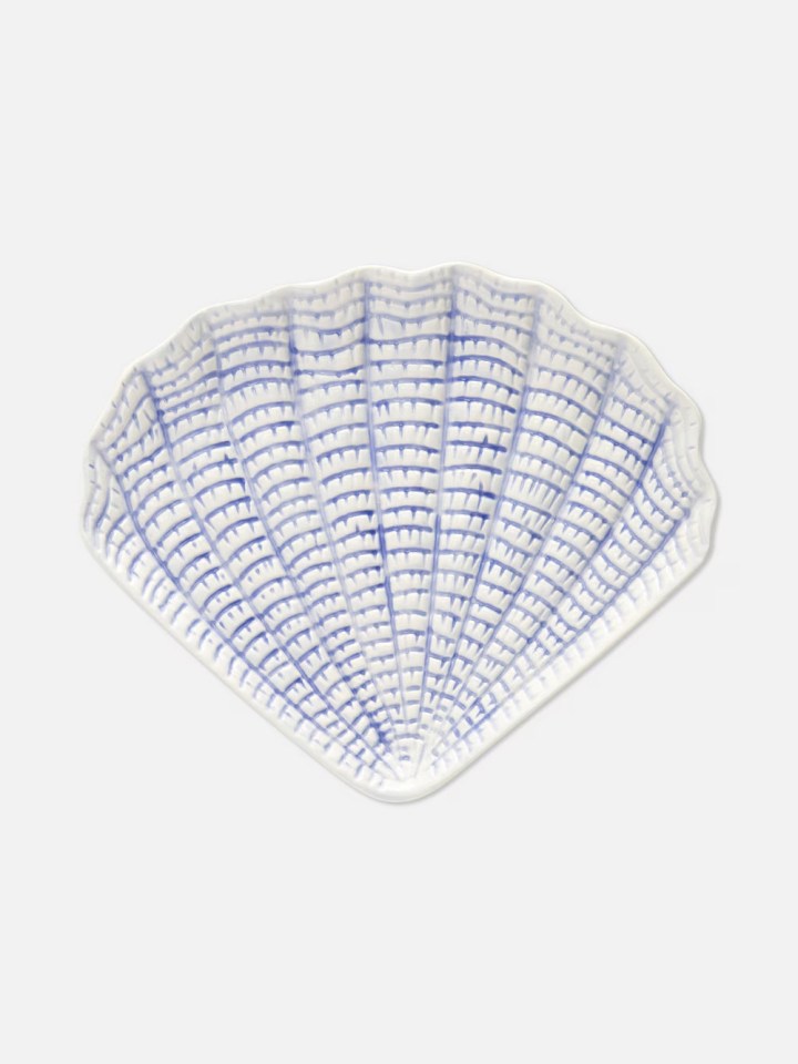 Shell-shaped plate with blue design.