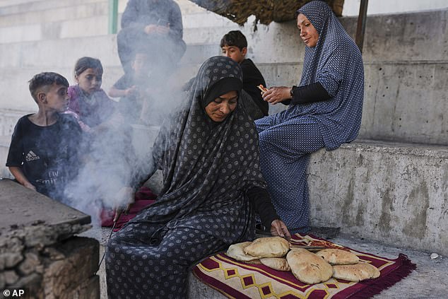 Displaced Palestinians prepare bread in a makeshift oven in Gaza City, Monday, May 5, 2025