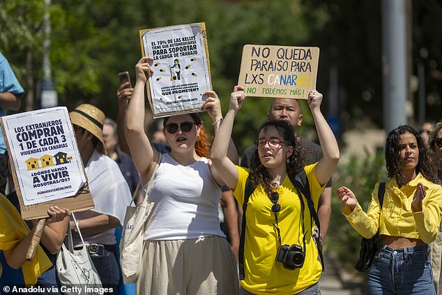 Protesters in Barcelona hold up signs which read: 'No queda paraiso para Lxs Canaria,' translating to 'There is no paradise left for the Canary Islands'