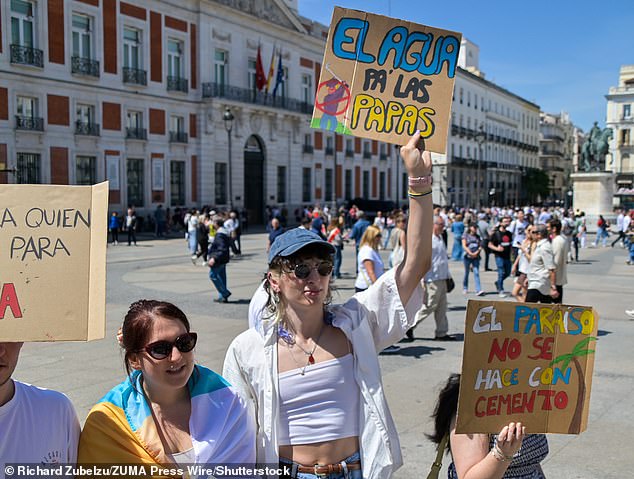 Others in Madrid hled up signs which read: 'El paraiso no se hace con cemento,' meaning: 'Paradise is not made with cement'