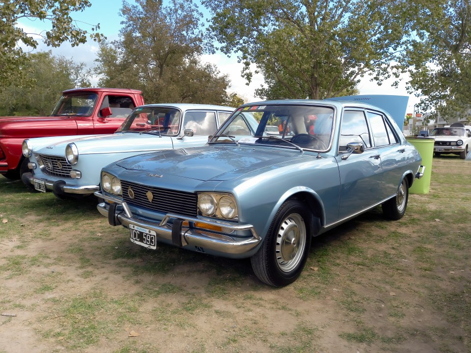 Light blue 1970 Peugeot 504 sedan at a classic car show.