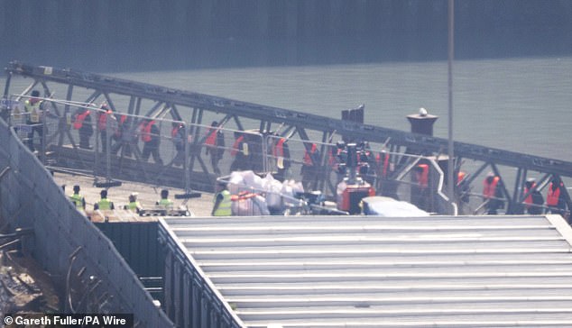 Migrants disembark from a Border Force catamaran at the Port of Dover on May 1, 2025