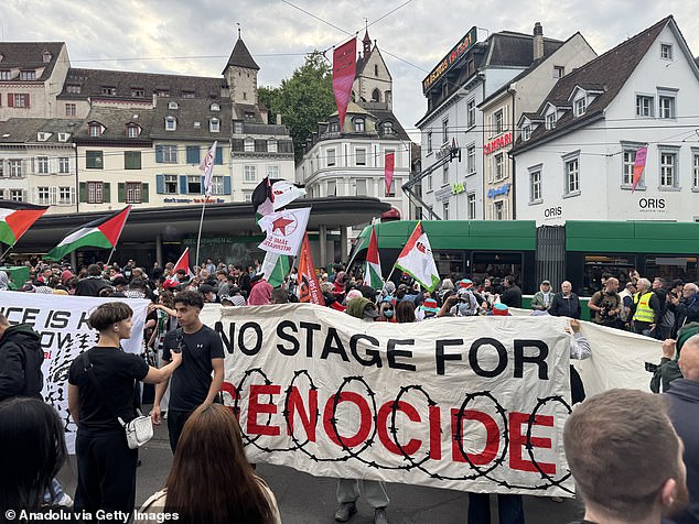 She has received heavy criticism, from jeers and boos in her preview to ex-winners signing letters to ban the country from Eurovision. Pictured: Protesters in Basel on Saturday