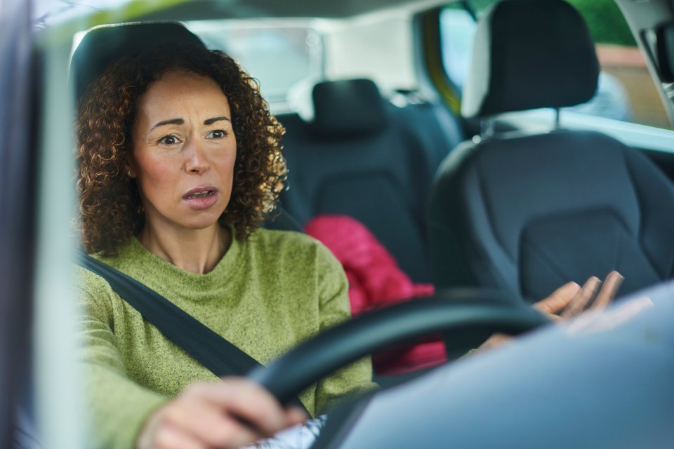 Frustrated woman driving a car.