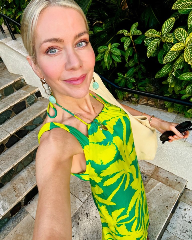 Woman in a green and yellow dress on a staircase.