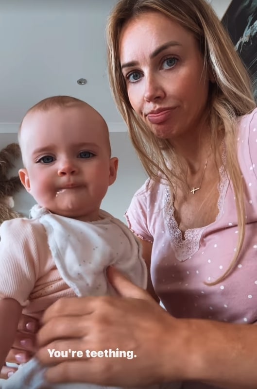 Woman holding baby who is teething.