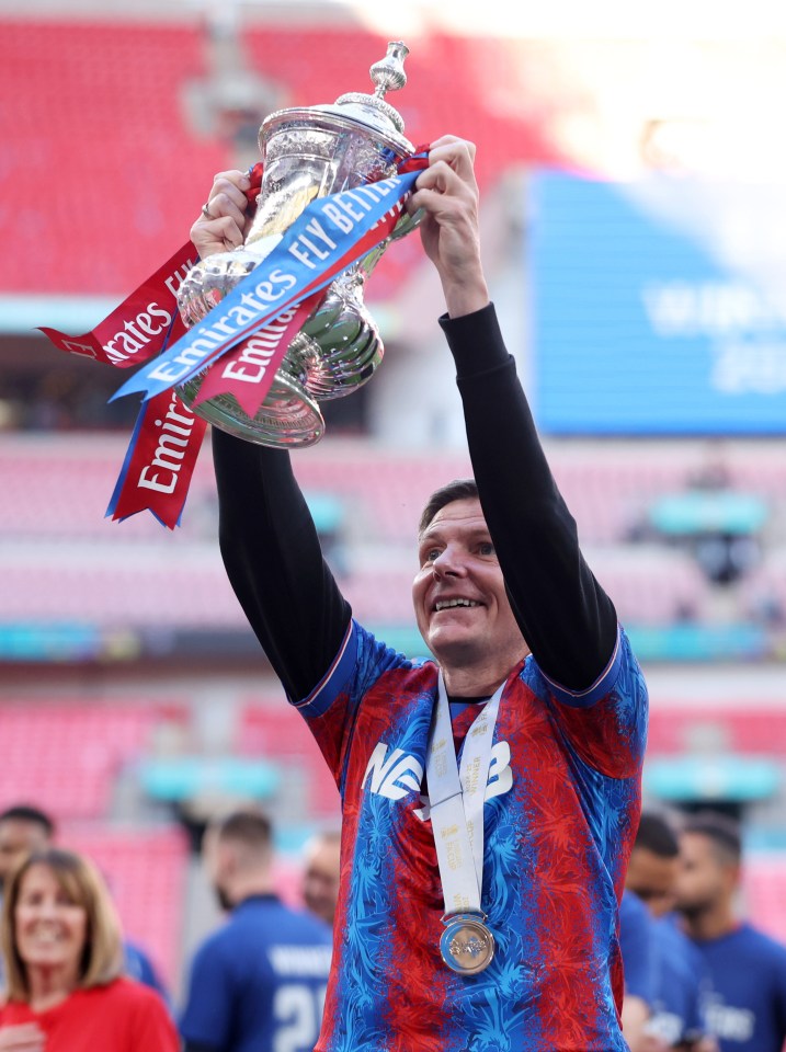 Crystal Palace manager holding up a trophy.