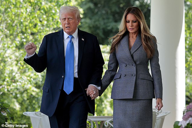 President Donald Trump and first lady Melania Trump hold hands as they enter a Rose Garden event for the 'Take it Down Act'