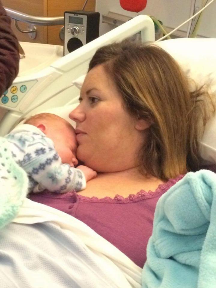 Mother and newborn baby resting in a hospital bed.