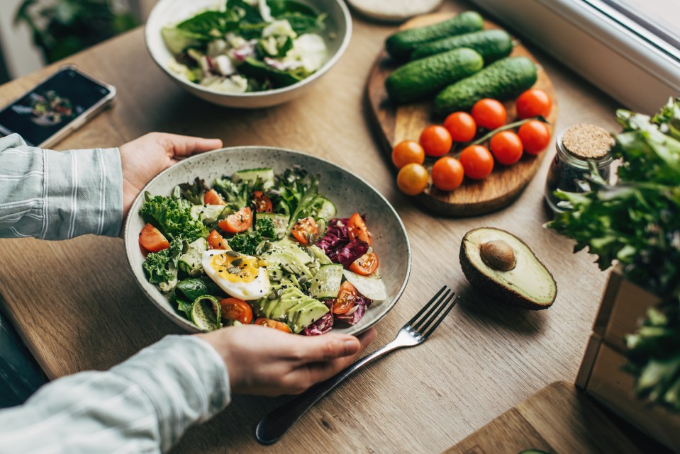 Person holding a bowl of superfood salad.