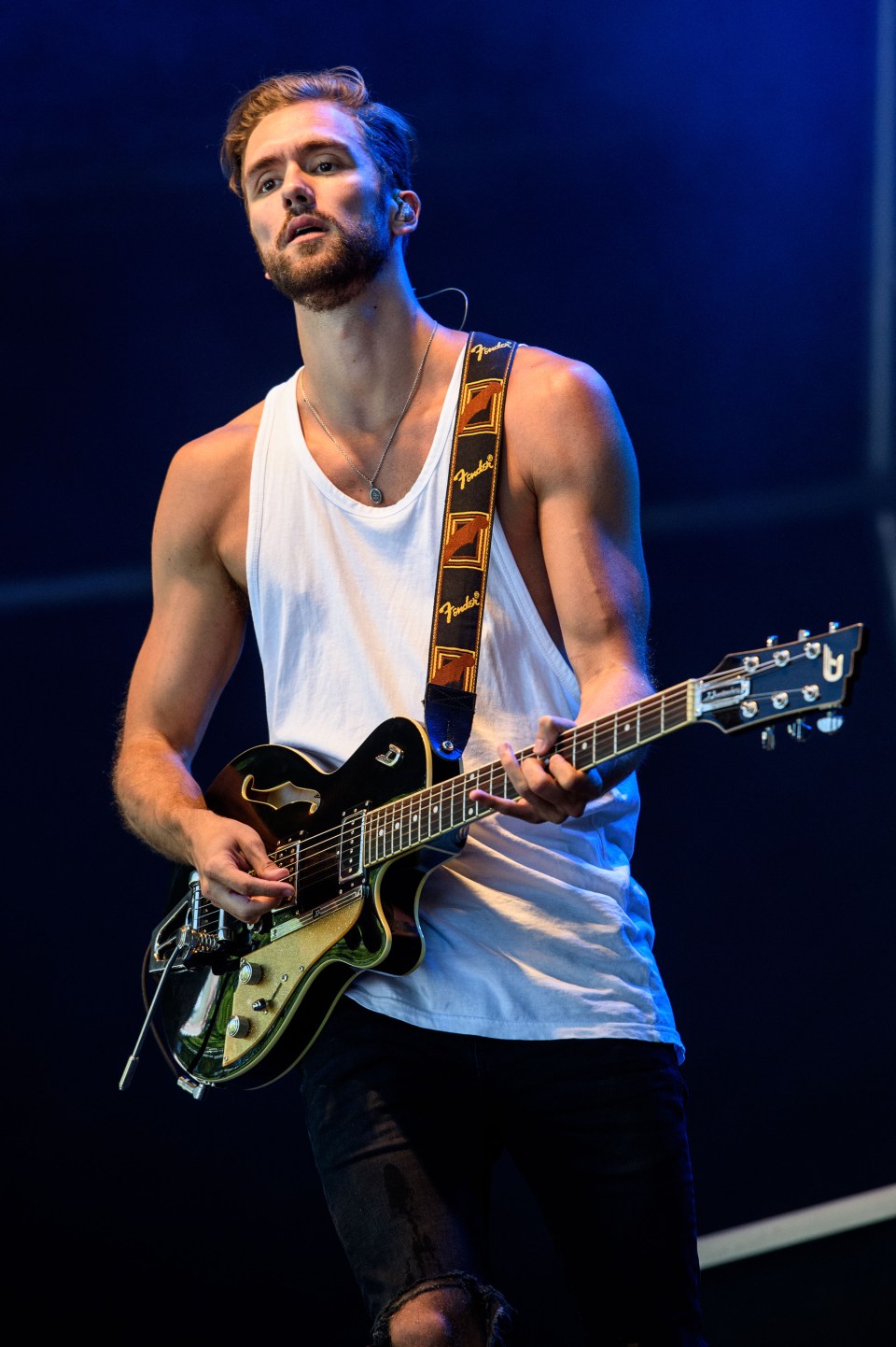 Andy Brown of Lawson performing on stage with an electric guitar.