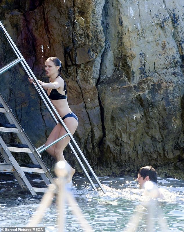 The mystery man was wading in the water as the movie icon made her way up the steps
