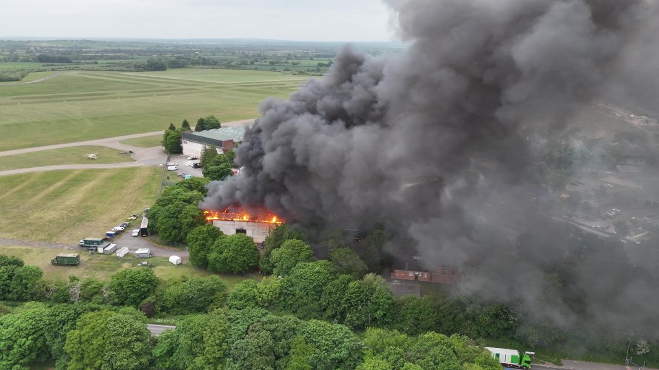 Aerial view of a large fire and thick black smoke at Bicester Motion.