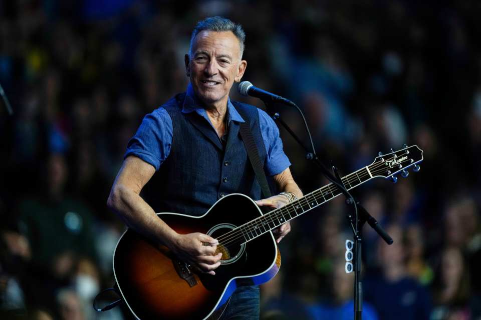 Bruce Springsteen performing with an acoustic guitar.