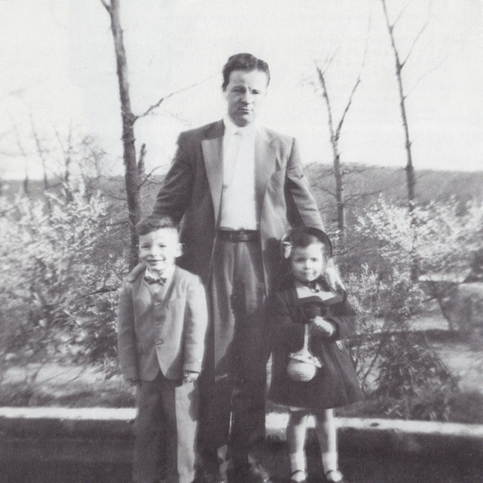 Black and white photo of Bruce Springsteen as a child with his father and sister.