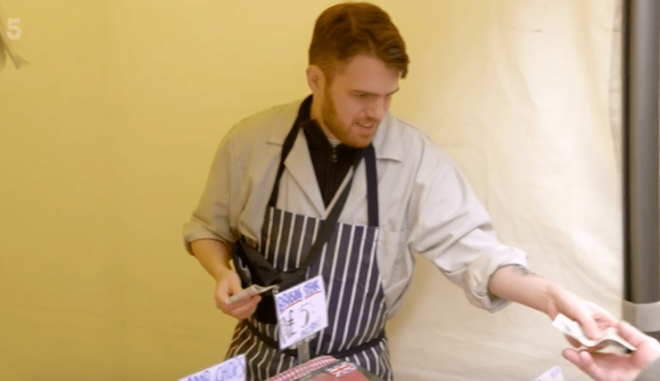 A butcher taking money from a customer.