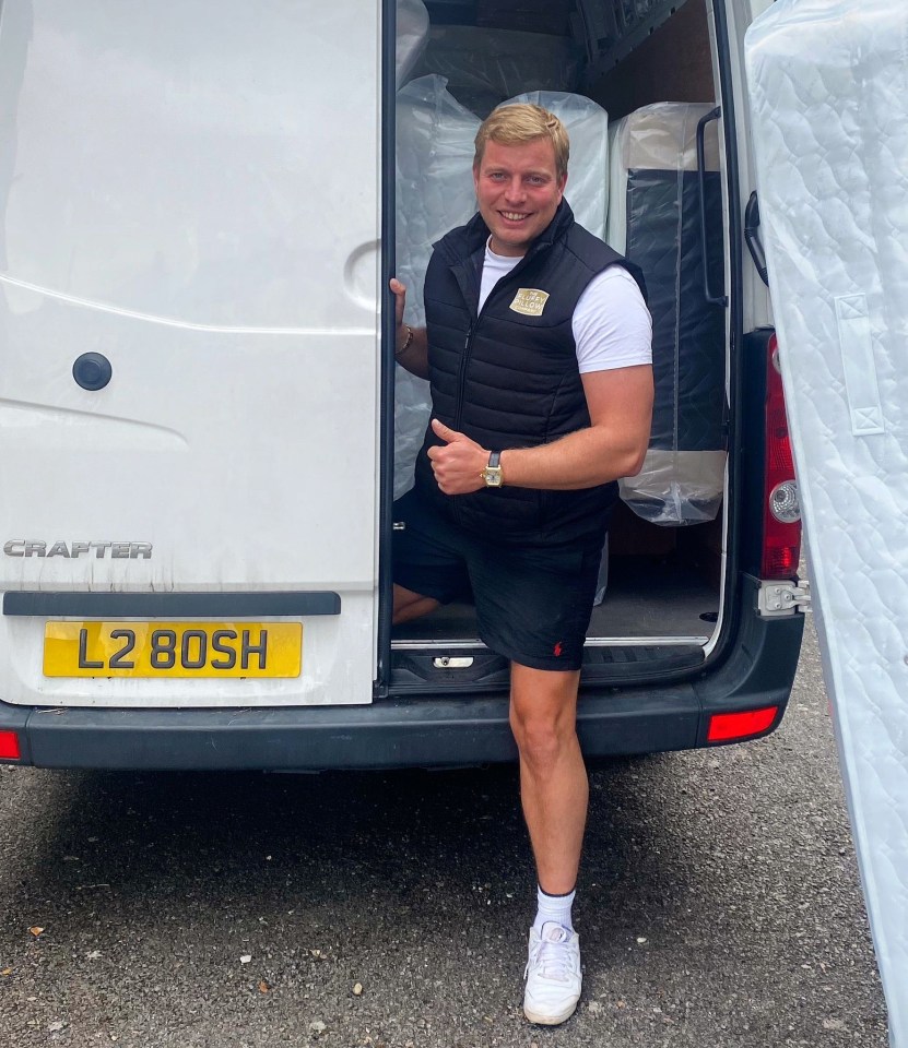 Man giving thumbs up next to van full of mattresses.