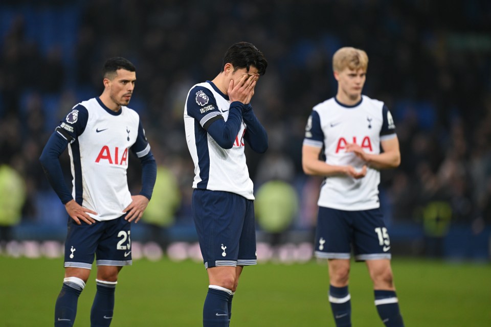 Three dejected Tottenham Hotspur players on the field after a match.