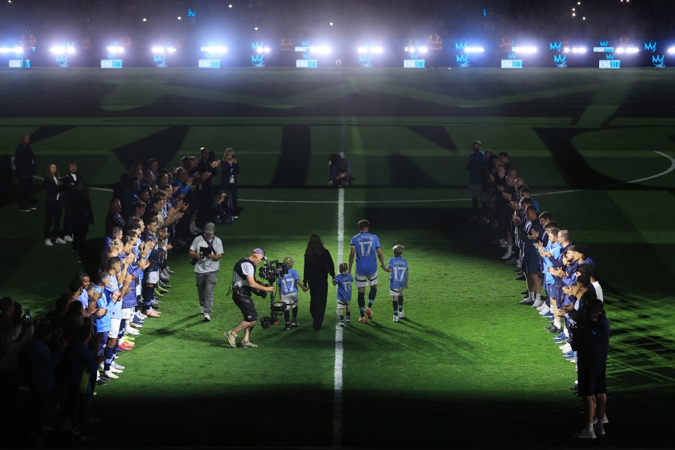 Kevin De Bruyne with his family, walking through a guard of honor of Manchester City players.