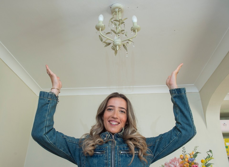 Woman in denim jacket admiring a new chandelier.