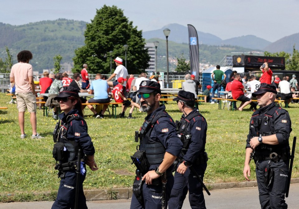 Police officers patrolling a crowd of people.