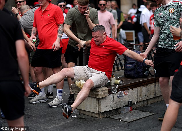 One fan loses his balance and knocks over his drink during the build up to the big game