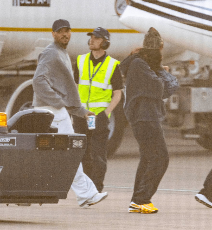 Three people walking on an airport tarmac.
