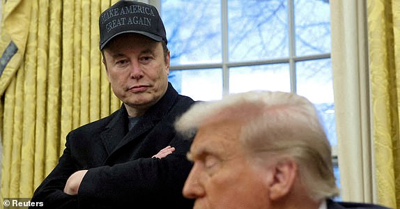 FILE PHOTO: Elon Musk listens to U.S. President Donald Trump speak in the Oval Office of the White House in Washington, D.C., U.S., February 11, 2025.   REUTERS/Kevin Lamarque/File Photo