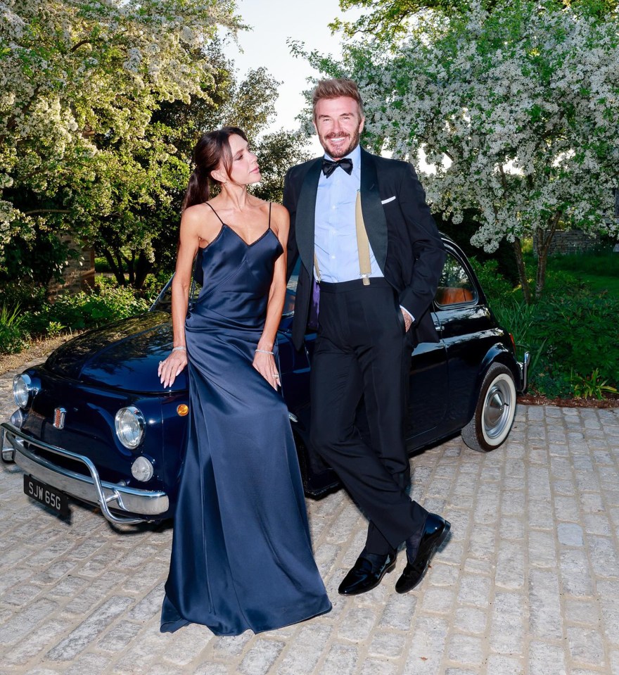 David and Victoria Beckham posing by a classic car.