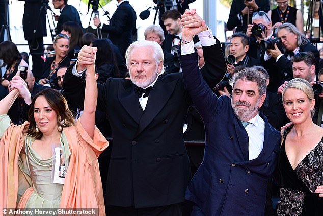The couple posed alongside Eugene Jarecki and Jennifer Robinson as they all raised their hands in the air