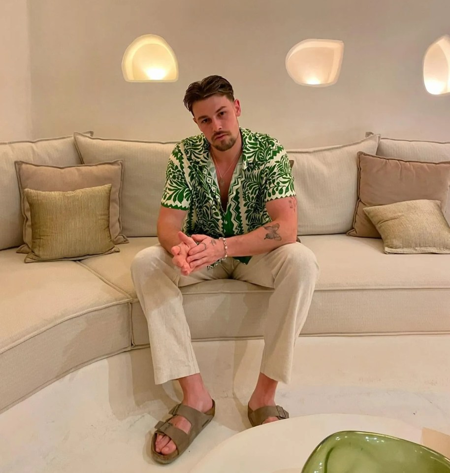 Andrew Le Page sitting on a beige couch.