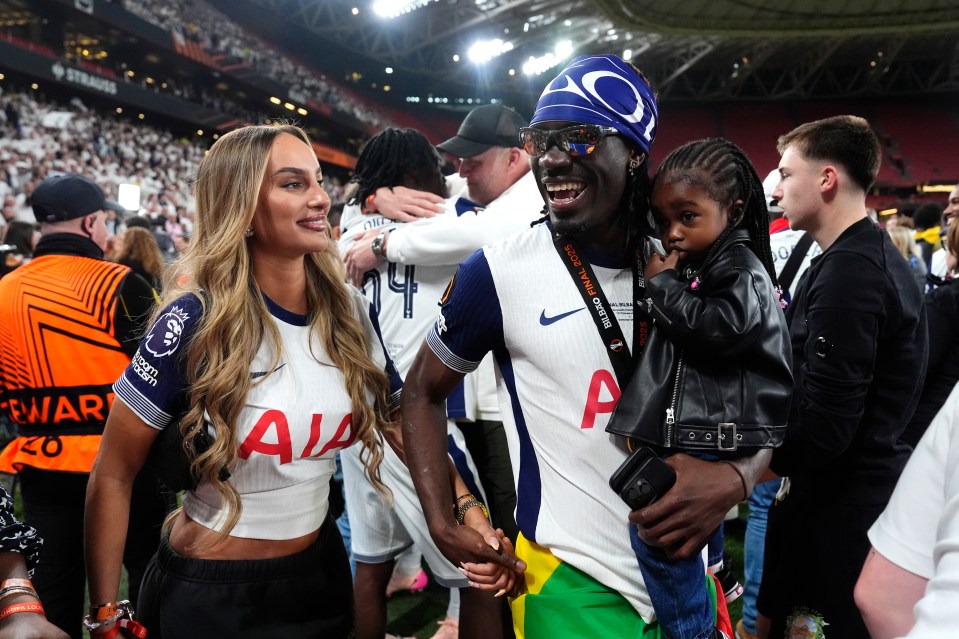 Yves Bissouma celebrates with his girlfriend and child after a soccer victory.