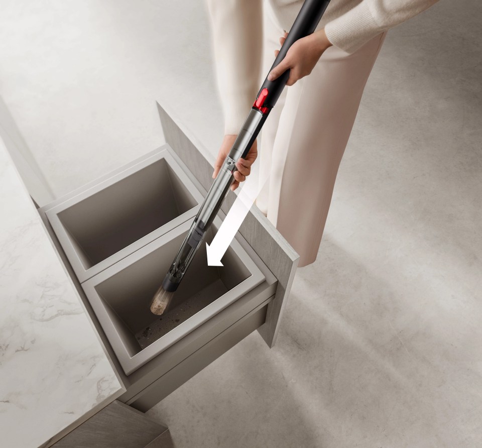 Emptying a handheld vacuum into a kitchen drawer.