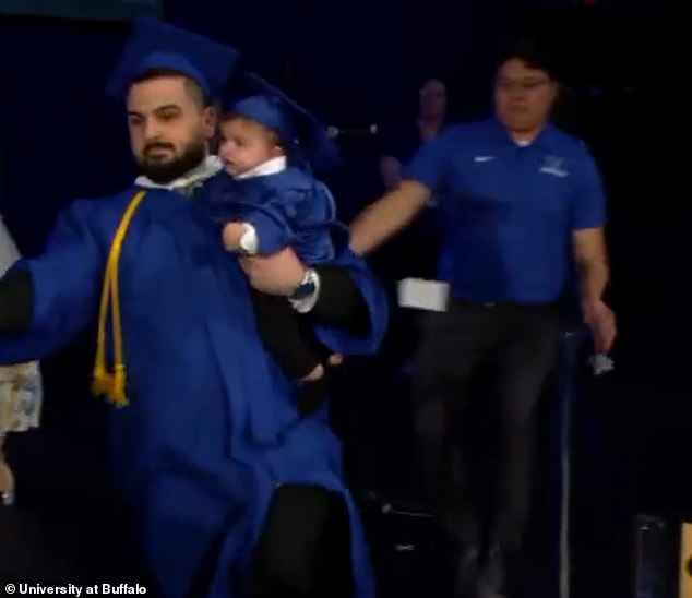 In the video that has been viewed more than six million times on TikTok, Al Arab is seen rushing across the stage with his infant in hand, desperately trying to evade officers and event staff attempting to stop him from walking (pictured)