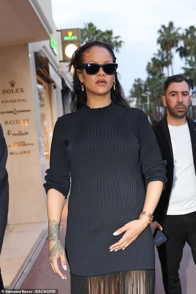 The Barbadian singer, 37, put on a stylish display in a fitted black ribbed mini dress with a unique fringed maxi skirt