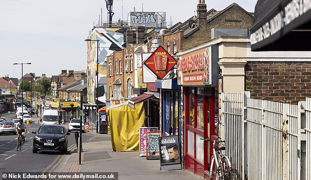 In the backdrop of a kebab shop in Thornton Heath is a building fully clad in street art