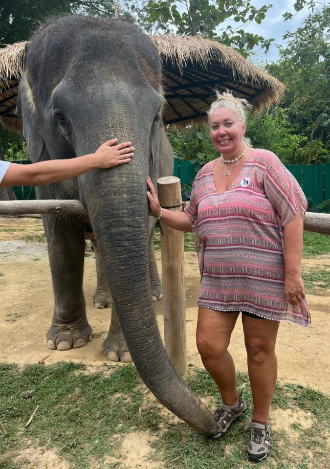 Woman standing next to an elephant.