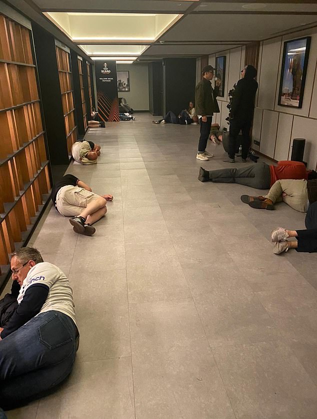 Supporters sleep on the floor of a hotel after a night of partying