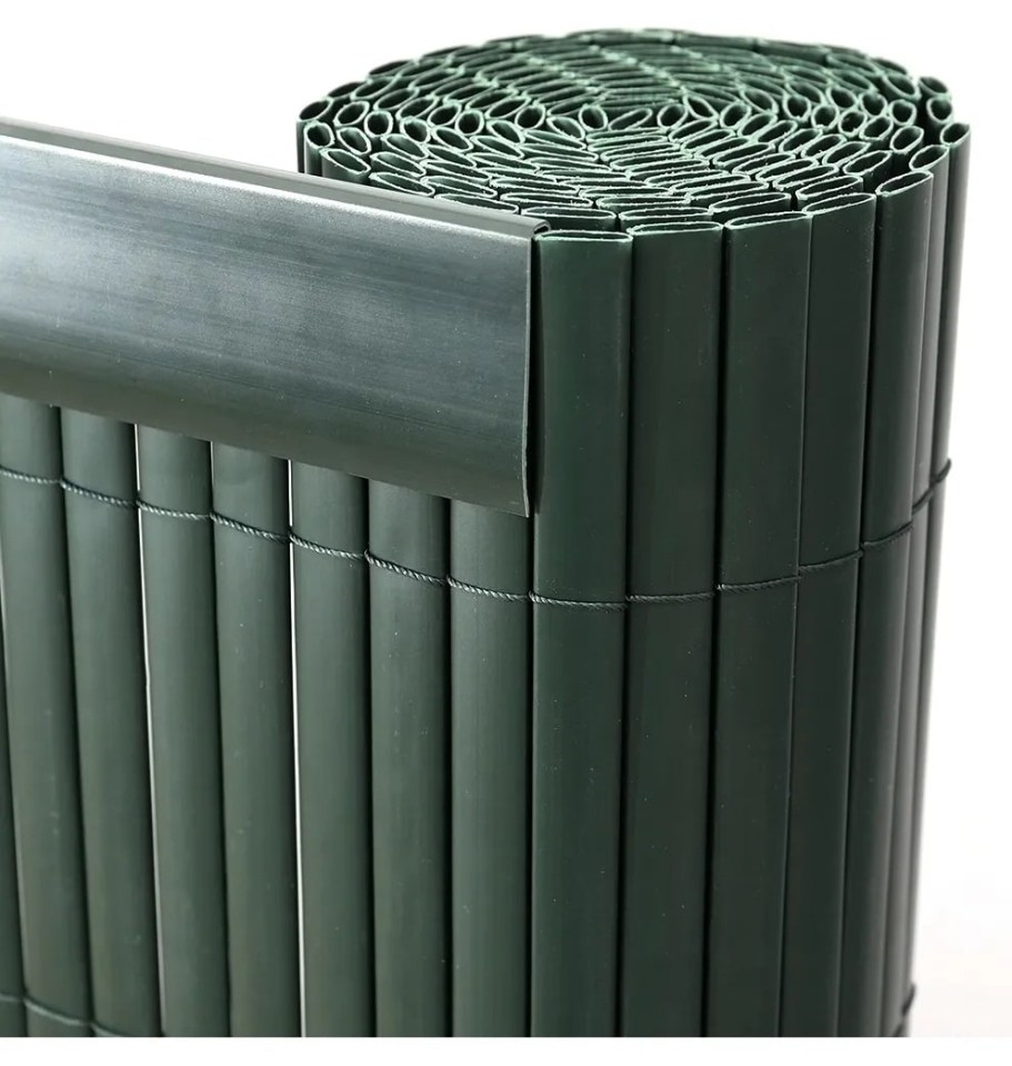 Rolled-up dark green plastic fence privacy screen.