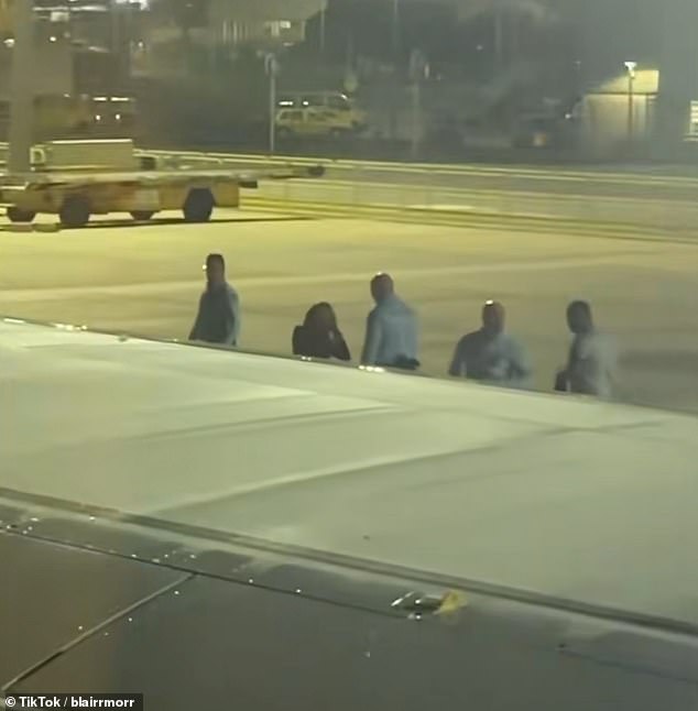 The woman was led off the plane by authorities