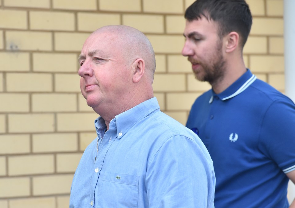 Two men standing outside a brick building.