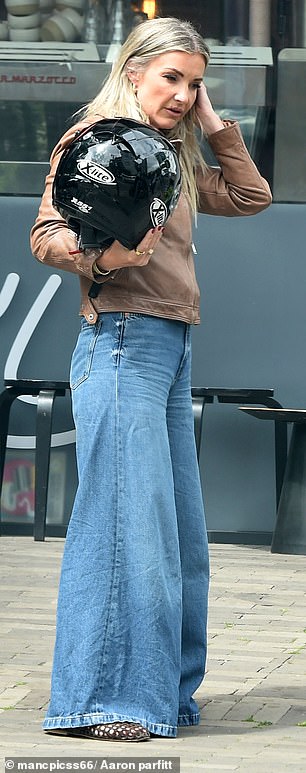 She paired the jacket with a wide-leg pair of denim jeans and mesh brown slip-on shoes