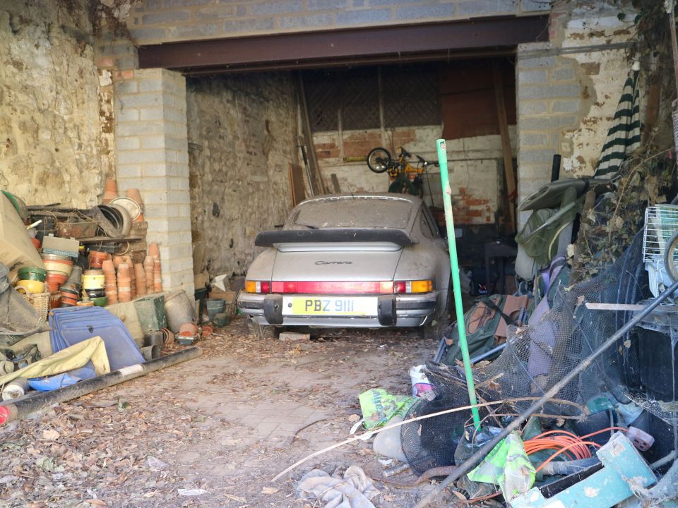 Dusty Porsche 911 in a cluttered garage.