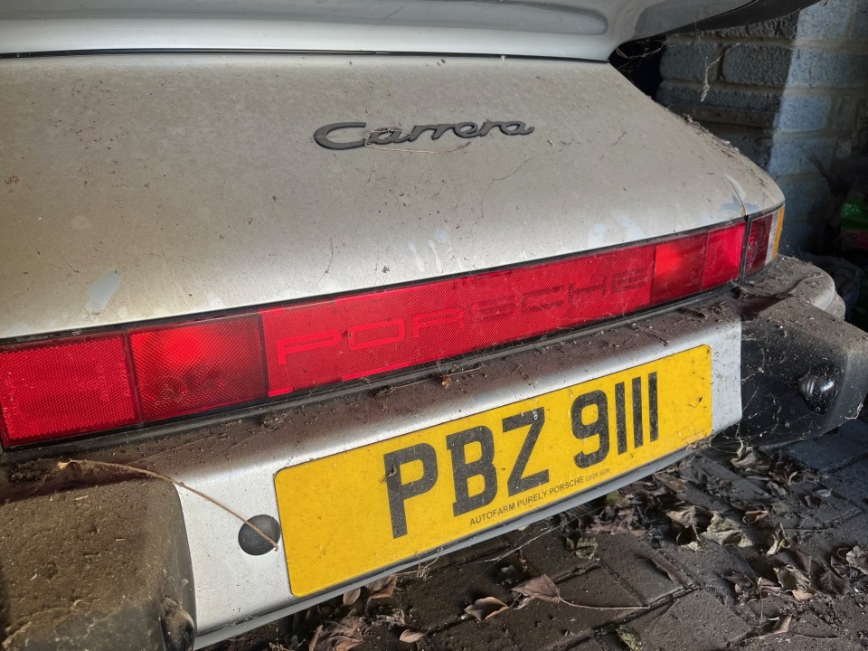 Dusty silver Porsche 911 in a barn.