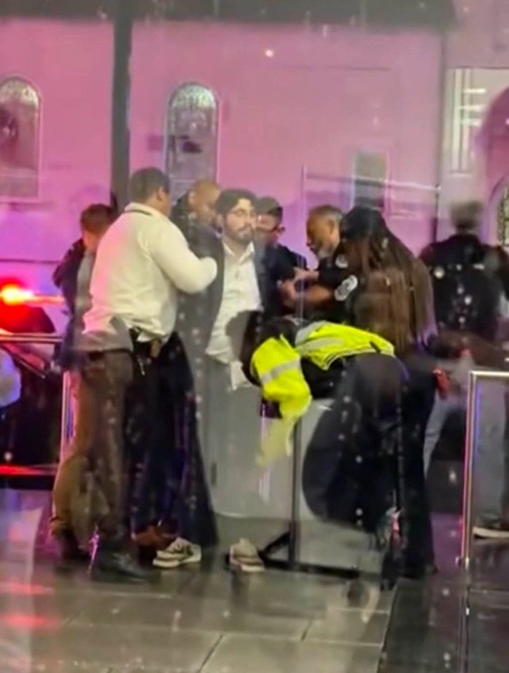 Police officers detaining a suspect near the Israeli embassy after a shooting.