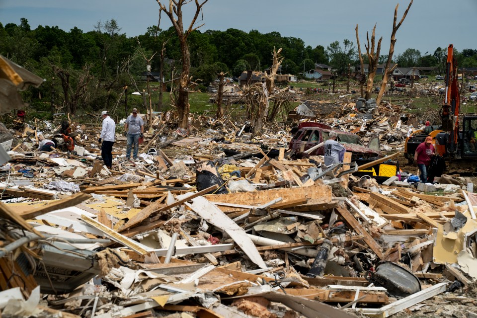 Debris and people cleaning up after a tornado.